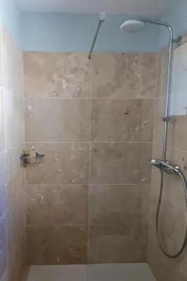 a bathroom with a shower with a glass door at La Goutadou in Cabannes