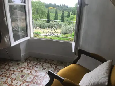 a chair in front of a window with a view at Oustau du Ventoux in Bédoin