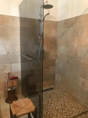 a shower with a glass door in a bathroom at Oustau du Ventoux in Bédoin