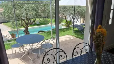 a balcony with a table and chairs and a pool at Le Mas de la Tortue (Plain Pied) in Caromb