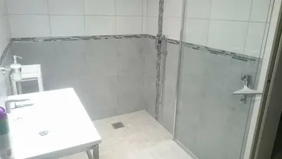 a shower with a glass door next to a sink at Les Figues in Caromb