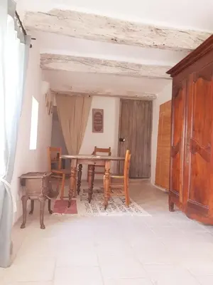 a dining room with a wooden table and chairs at Chambres entre Ventoux et luberon in Sault-de-Vaucluse