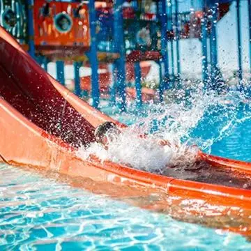 a child sliding down a water slide in a pool at Chambres entre Ventoux et luberon in Sault-de-Vaucluse