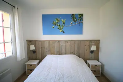 a bedroom with a bed with two nightstands and two lamps at 225 Chemin des Joncs in Saint-Pierre-de-Vassols