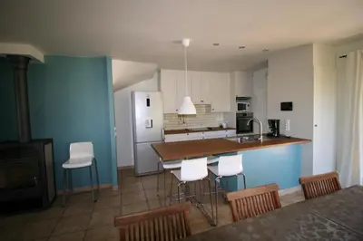 a kitchen with white cabinets and a blue wall at 225 Chemin des Joncs in Saint-Pierre-de-Vassols