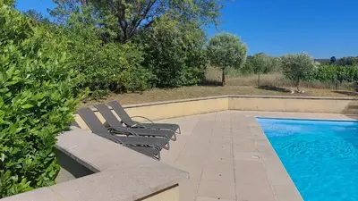 a pair of benches sitting next to a swimming pool at 225 Chemin des Joncs in Saint-Pierre-de-Vassols