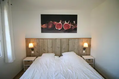 a bedroom with a white bed with two night stands at 225 Chemin des Joncs in Saint-Pierre-de-Vassols
