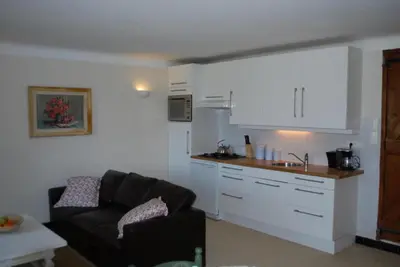a living room with a couch and a kitchen at Amandier in Mazan