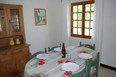 a dining room table with a bottle of wine on it at Amandier in Mazan
