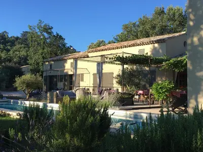 a house with a swimming pool in front of it at Une Sieste en Luberon in Bonnieux