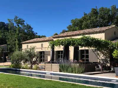 an old house with a pool in front of it at Une Sieste en Luberon in Bonnieux