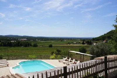 a swimming pool with chairs and a fence at Acacia in Mazan