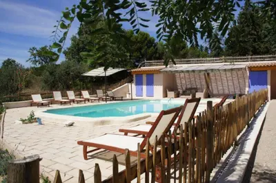 a swimming pool with lounge chairs and a wooden fence at Acacia in Mazan