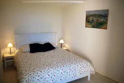 a bedroom with a bed and a painting on the wall at Olivier in Mazan