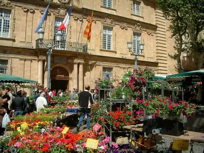a group of people walking around a market with flowers at Granet Studio in Aix-en-Provence