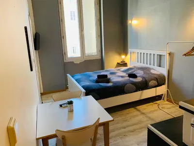 a small room with a bed and a table at Mirabeau Studio in Aix-en-Provence