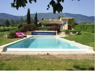 a swimming pool in front of a house at La Bastide des Vasses l'Atelier in Cucuron
