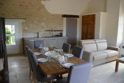 a dining room with a wooden table and chairs at Les Gîtes Du Clos D'Olea in Oppède