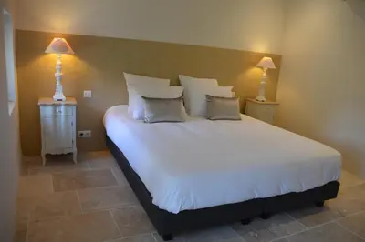 a bedroom with a large white bed with two lamps at Les Gîtes Du Clos D'Olea in Oppède