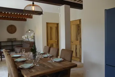 a dining room with a wooden table and chairs at Les Gîtes Du Clos D'Olea in Oppède