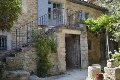 an old stone house with a staircase and a door at Les Gîtes Du Clos D'Olea in Oppède