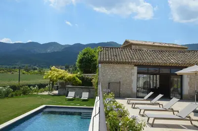 a villa with a swimming pool and lounge chairs at Le Clos D'Olea in Oppède