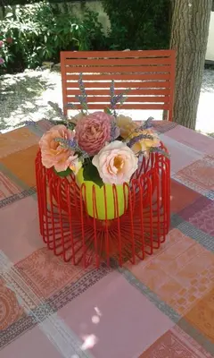 a cake with flowers in a red basket on a table at La Bastide des Vasses 