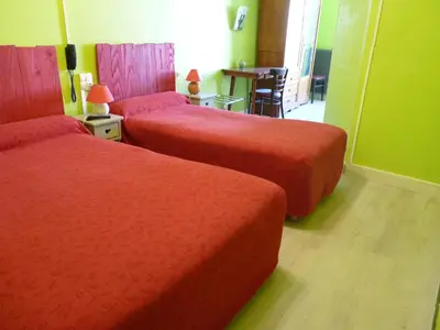 a hotel room with two beds with red covers at Hotel Régina in Salon-de-Provence