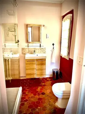 a bathroom with a toilet and a sink and mirror at La Sarrasine in Villes-sur-Auzon
