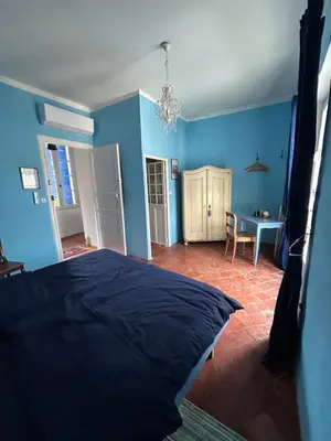 a blue bedroom with a bed and a table at La Sarrasine in Villes-sur-Auzon