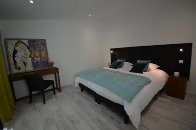 a bedroom with a large bed and a chair at Domaine Shambala - gîte en Provence avec une Grande Piscine in Velaux