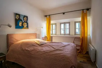 a bedroom with a bed with orange curtains at Stunning panoramic views and heated pool in Roussillon in Roussillon