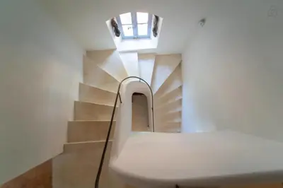 a stairwell with a white bench and a window at Stunning panoramic views and heated pool in Roussillon in Roussillon