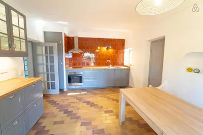 a kitchen with blue cabinets and a sink and a table at Stunning panoramic views and heated pool in Roussillon in Roussillon