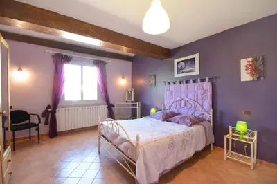 a bedroom with a bed and a purple wall at Villa charmante à Saint-Didier avec piscine privée in Saint-Didier