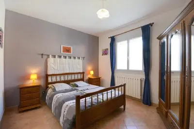a bedroom with a bed and two night stands and a window at Villa charmante à Saint-Didier avec piscine privée in Saint-Didier