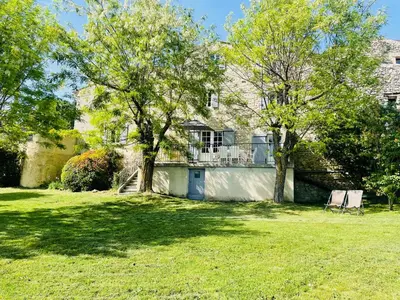 a house with a tree and two chairs in a yard at Gîte La Bastide de La Loge au pied du Mont Ventoux in Sault-de-Vaucluse