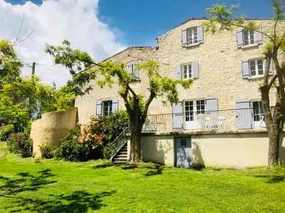 an old stone house with a tree in the yard at Gîte La Bastide de La Loge au pied du Mont Ventoux in Sault-de-Vaucluse