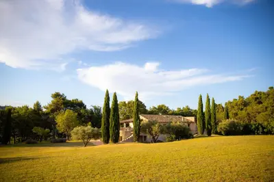 a house in a field with cypress trees at Le Mas Sérénité in Ansouis