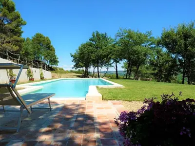 a swimming pool with a bench next to a yard at Le Mas Sérénité in Ansouis