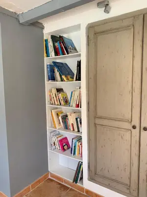 a book shelf filled with books next to a door at Le Mazet Des Joncs en Provence in Saint-Pierre-de-Vassols