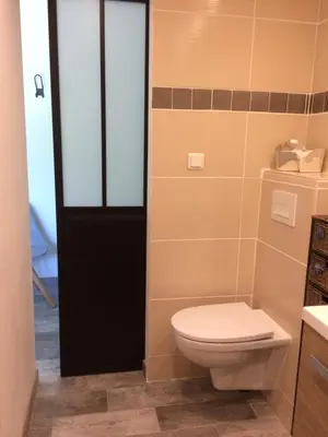 a bathroom with a toilet and a black door at Le Mazet Des Joncs en Provence in Saint-Pierre-de-Vassols