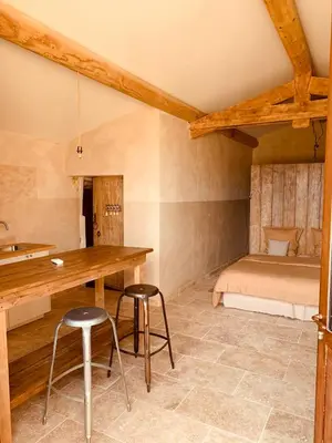 a room with a table and two stools and a bed at Le Vieux Portail in Saint-Saturnin-les-Apt