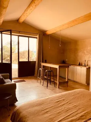 a bedroom with a bed and a table in a room at Le Vieux Portail in Saint-Saturnin-les-Apt
