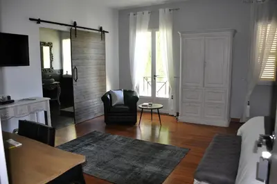 a living room with a couch and a chair at Le Jardin des Amandiers in Châteaurenard