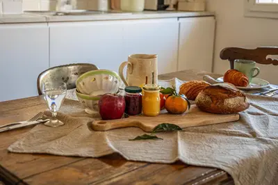 a table with a cutting board with apples and bread at Le 40 in LʼIsle-sur-la-Sorgue