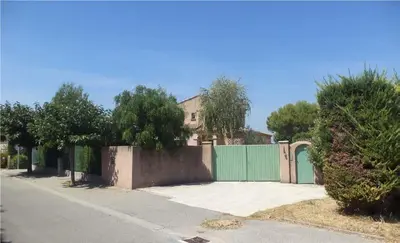 a house with a green fence next to a street at Vakantiehuis Mazan - Le Haut Colombier in Mazan