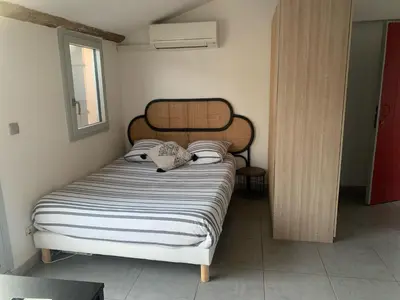 a bedroom with a bed with a black and white comforter at Studio avec Terrasse in Aix-en-Provence
