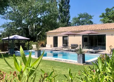a villa with a swimming pool in a yard at In Elsama piscine chauffée in LʼIsle-sur-la-Sorgue