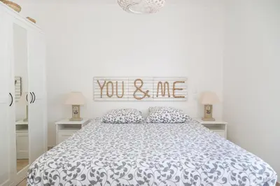 a white bedroom with a bed and a sign that reads you and me at In Elsama piscine chauffée in LʼIsle-sur-la-Sorgue